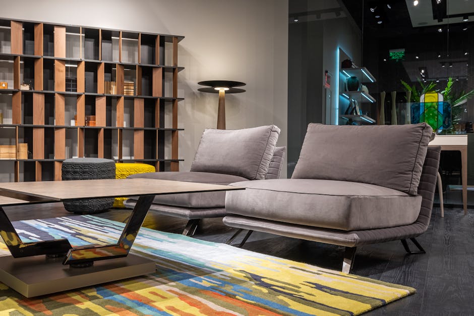 Comfortable settee placed near geometric table on carpet and bookcase in spacious apartment designed in creative style
